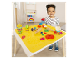 Een klein kind speelt met Play-Doh aan een tafel met een geïntegreerde speelmat.