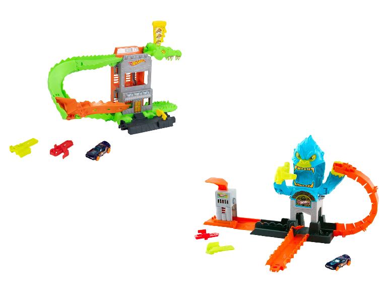 Twee speelgoedautoracebanen, één met een groene alligator en de andere met een blauw monster.