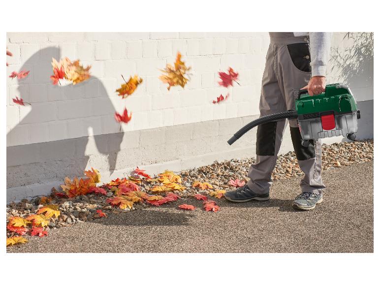 Man gebruikt een bladblazer om herfstbladeren van een pad te verwijderen.