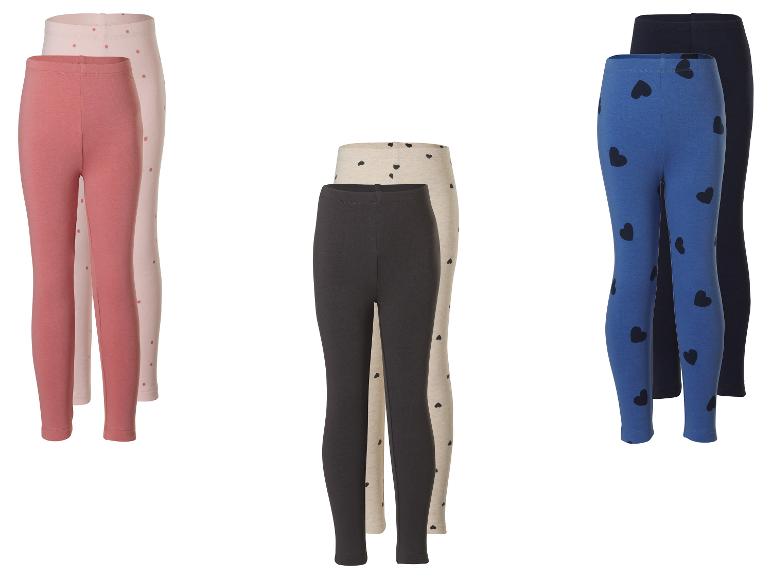 Drie paar kinderleggings: roze met stippen, beige met hartjes en blauw met hartjes.