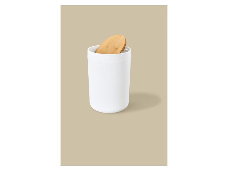 Witte cilindrische container met een houten deksel op een beige achtergrond