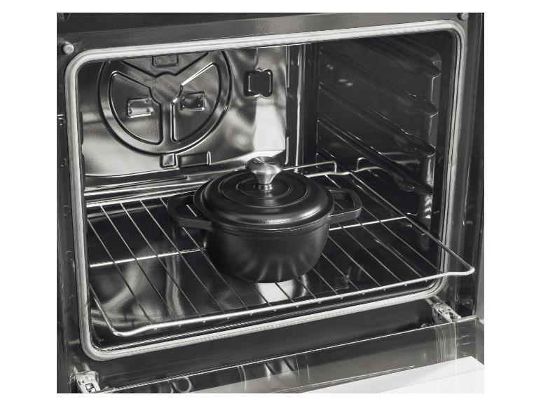 Zwarte gietijzeren pan in een moderne oven met een glanzende binnenkant.