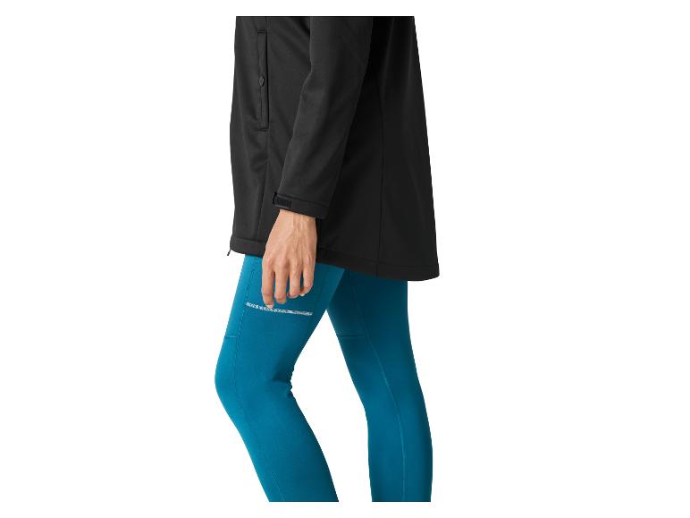 Vrouw in zwarte jas en turquoise legging.