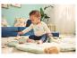 Baby zittend op een speelmat in een LUPILU® romper met lange mouwen.