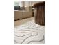 Beige vloerkleed met golvend patroon en houten salontafel in de woonkamer.