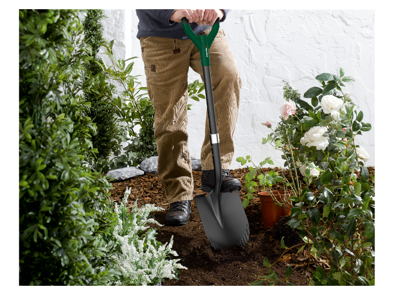 Een man gebruikt een Parkside schop om in de tuin te graven.
