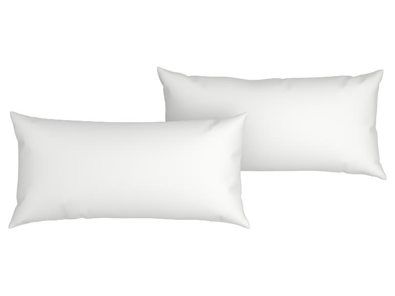 Twee witte kussens op een witte achtergrond.