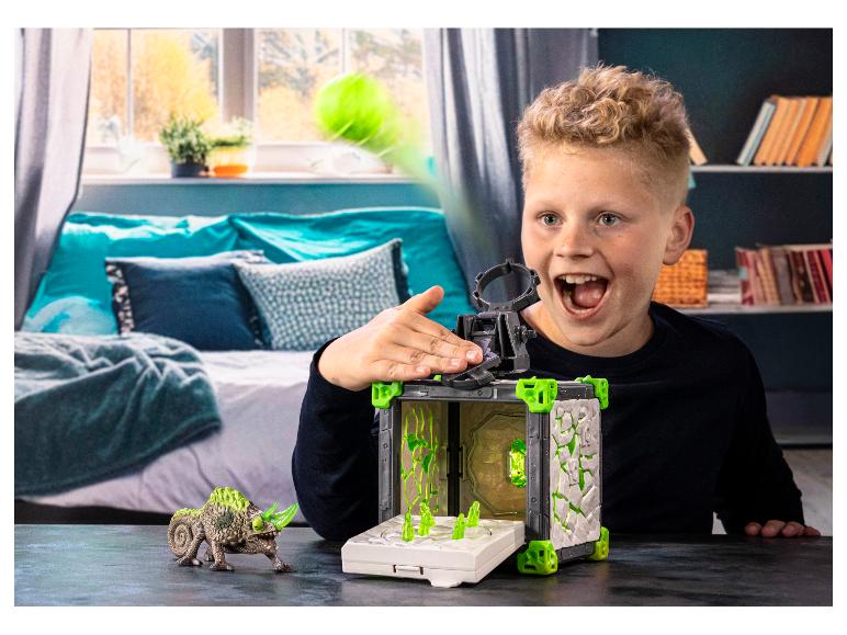 Jongen speelt met een lanceerspeelset en hagedisfiguur.