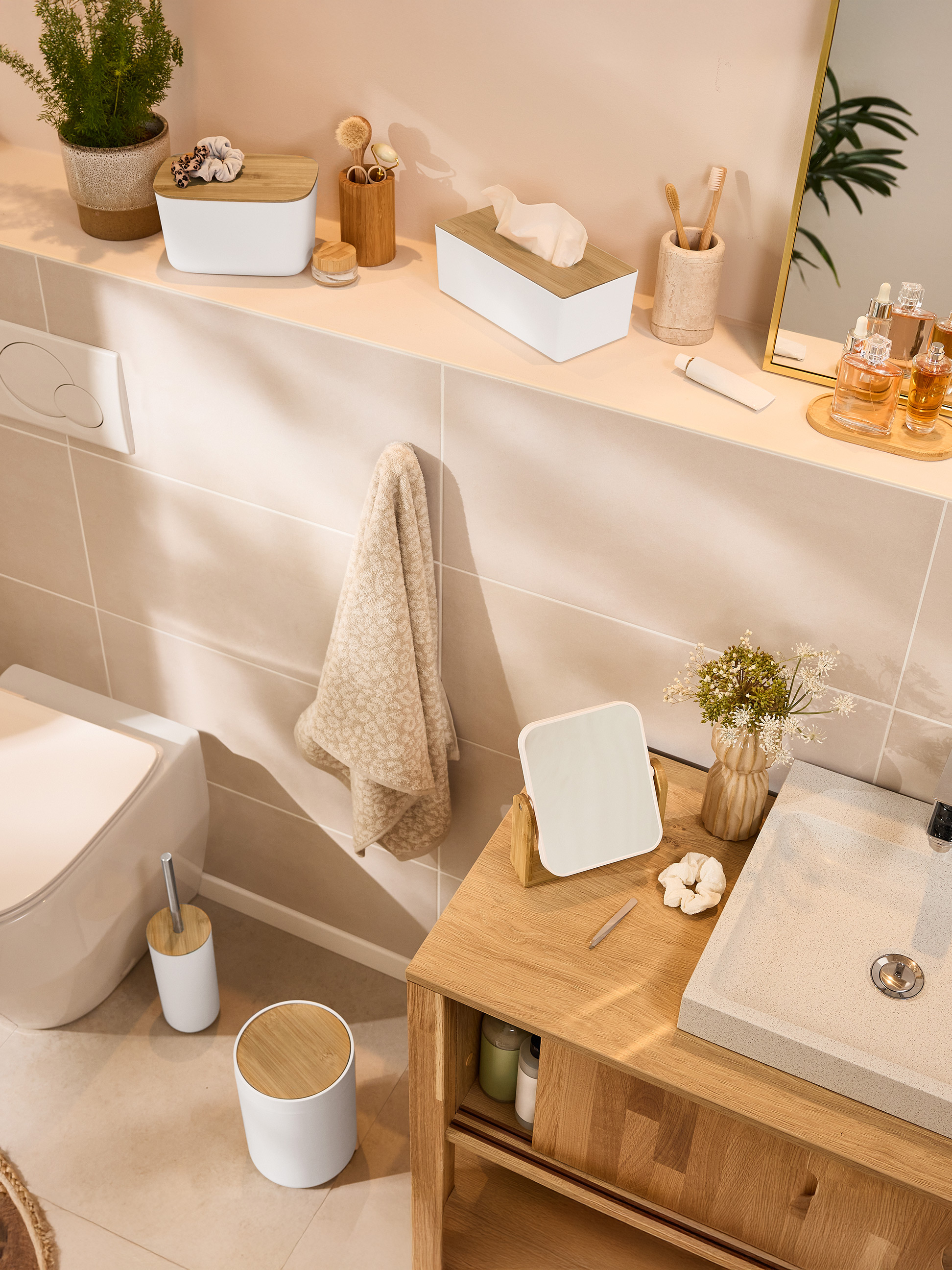 Badkamer met bamboe accessoires, toilet en wastafel.