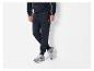 Man in donkerblauwe hoodie en donkerblauwe joggingbroek met grijze sneakers.