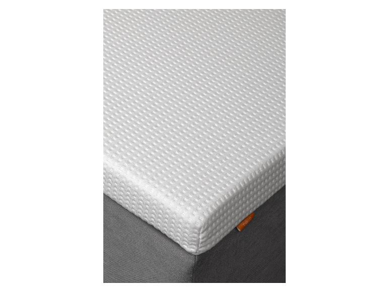 Wit matras met gestructureerd oppervlak op een donkergrijze ondergrond.