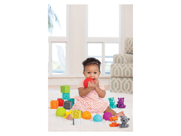 Baby speelt met sensorische blokken en ballen.