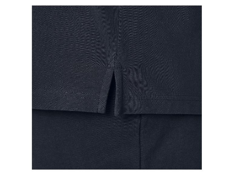Detail van een marineblauwe poloshirt met zijsplitten.