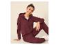Lachende jonge vrouw in bordeauxrode hoodie en joggingbroek.