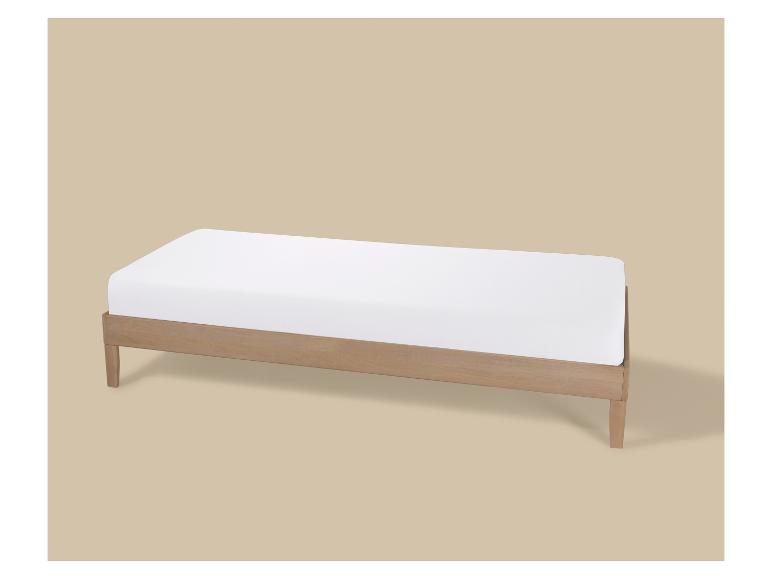 Houten eenpersoonsbed met wit matras op beige achtergrond.