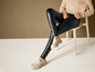 Zwarte lederlook leggings met witte loafers.