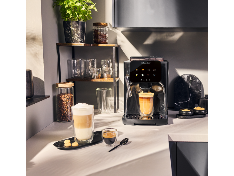 Volautomatisch koffiezetapparaat met koffie en latte macchiato in moderne keuken.