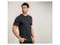 Man in zwart Henley-shirt en zwarte broek, kijkt naar rechts.