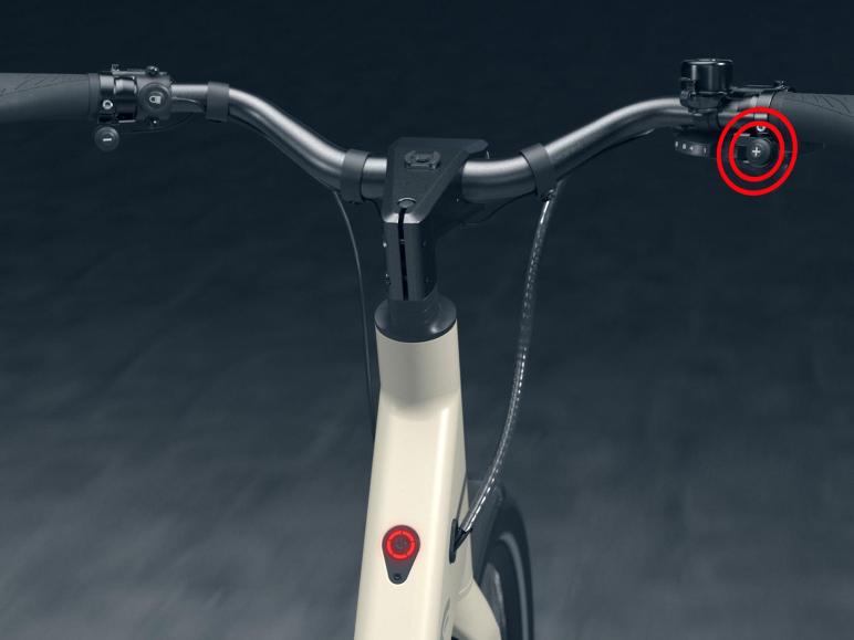 Het stuur van een witte elektrische fiets met bedieningselementen.