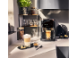Automatische koffiemachine met koffie en latte macchiato in glazen, op een aanrecht.