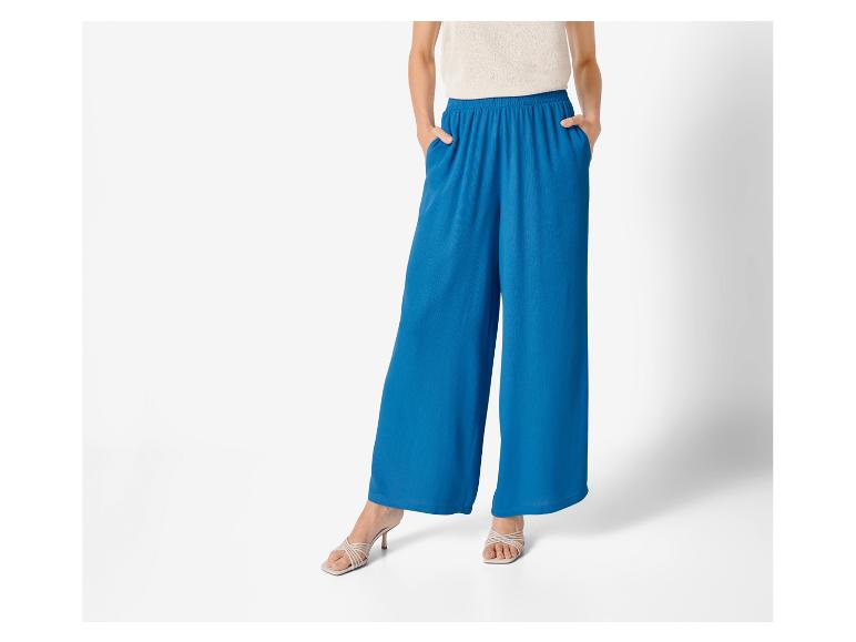 Brede blauwe broek en hakken: elegante damesmode.