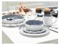 Tafel gedekt met modern grijs en wit servies, glazen en kookingrediënten.