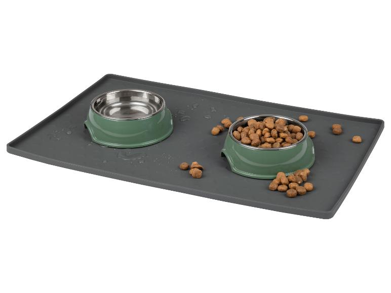 Grijze siliconen voedermat met twee saliegroene kommen; één kom is leeg, de andere bevat hondenvoer.