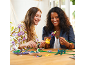 Twee vrouwen die vrolijk kleurrijke kunstbloemen en -planten in elkaar zetten.