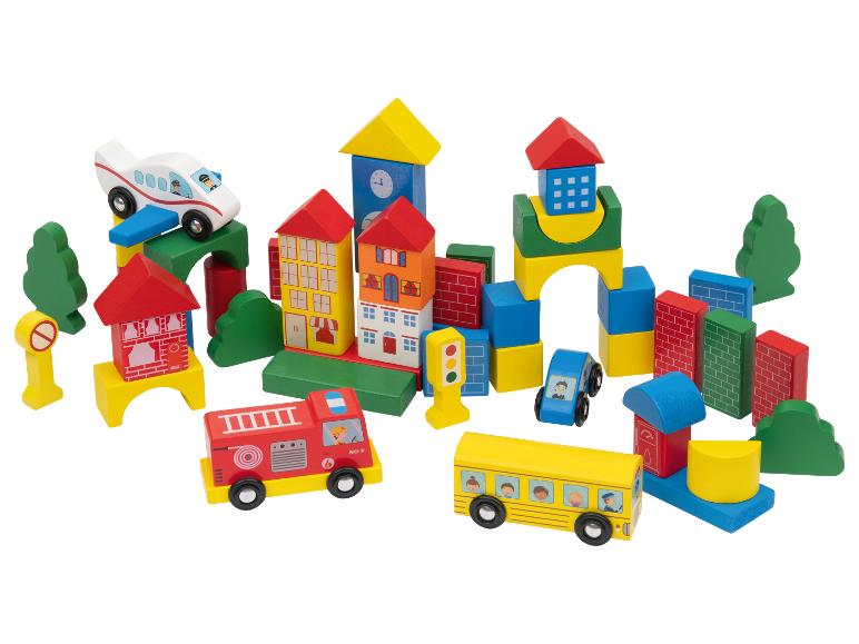 Kleurrijke houten speelgoedstad met gebouwen, voertuigen en bomen.