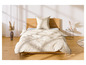 Een bed met beige beddengoed met een wit bloemenpatroon.