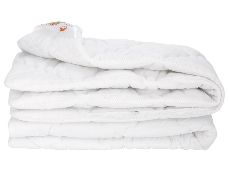 Een gevouwen witte, gewatteerde deken van Polygiene.