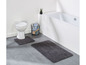 Twee badmatten in een badkamer met toilet en bad.