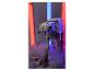 Grijze looprobot met afstandsbediening omringd door rode en blauwe lichten en rook.