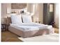 Bed met wit matras, kussens en topmatras in een moderne slaapkamer.