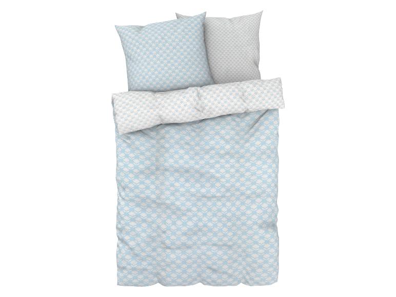 Een blauwe dekbedovertrek met witte bloemen en bijpassende kussens.