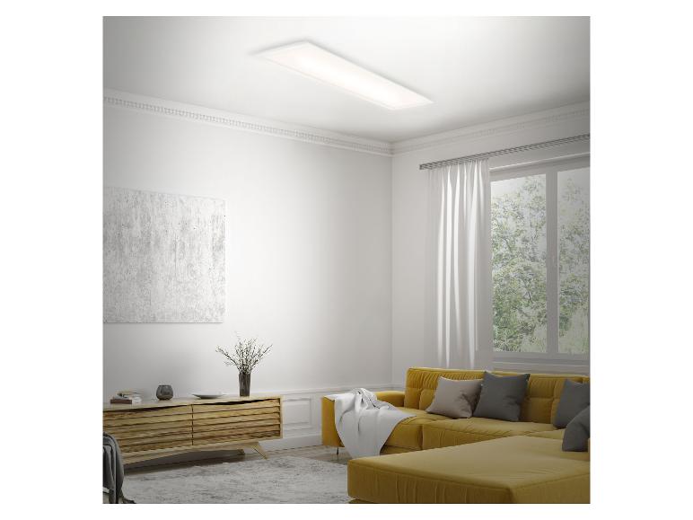 Moderne woonkamer met een gele bank, houten dressoir en een rechthoekige plafondlamp.