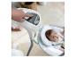 Hand past instellingen van babyschommel aan, baby ligt in de schommel
