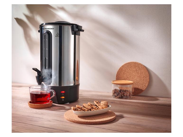 SilverCrest warmwaterdispenser met een kop thee en koekjes op een houten tafel.