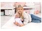 Een meisje houdt een Baby Annabell pop vast met olifantenprint.