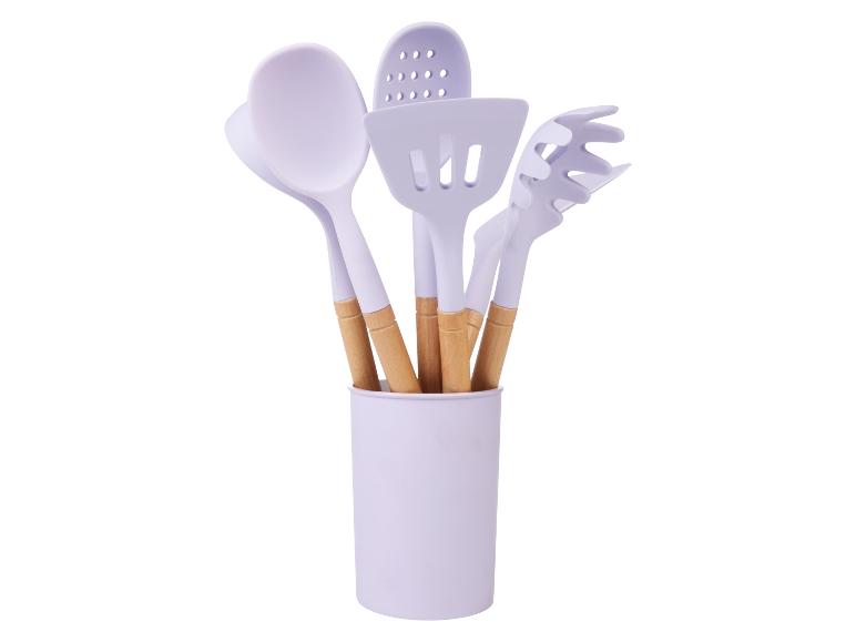 Lila keukenhulpjes met houten handvatten in een lila houder.