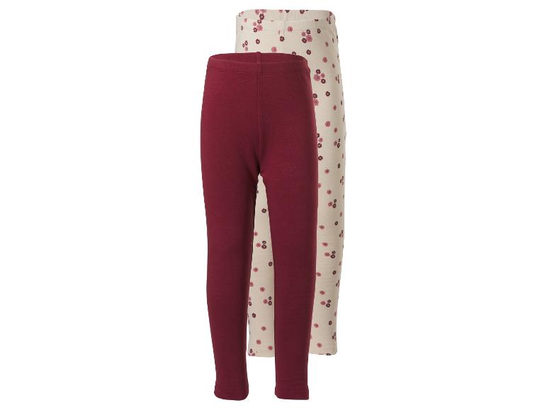 Twee baby leggings: één effen bordeaux en één crèmekleurig met bloemenpatroon.