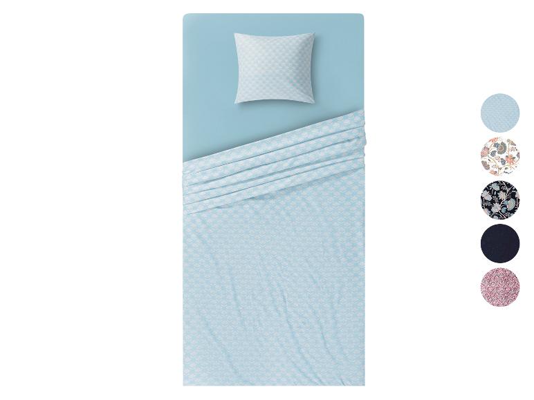 Een lichtblauwe dekbedovertrek met een wit geometrisch patroon.