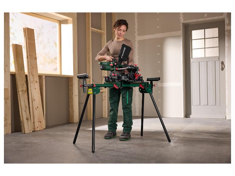 Vrouw bereidt afkortzaag voor op een standaard in een kamer met houten planken.