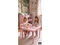 Twee meisjes spelen aan een roze tafel met stoelen, omringd door bosmeubels en decoraties.