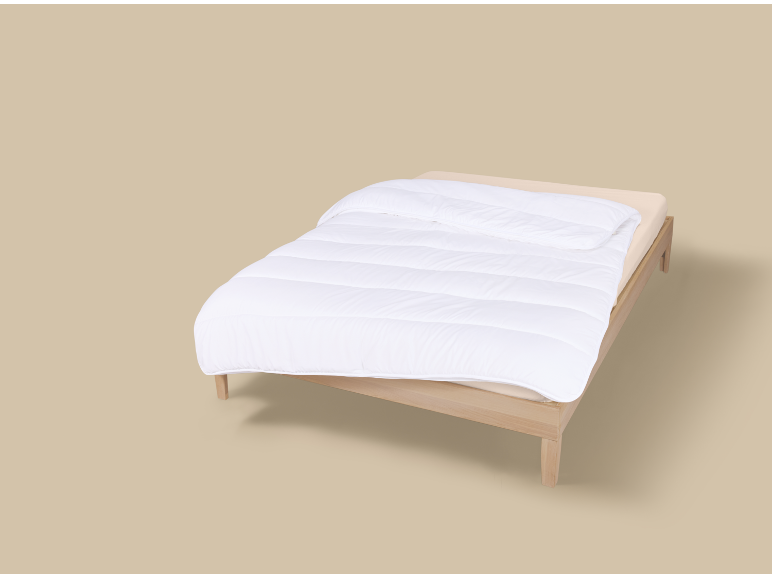 Eenpersoonsbed met wit dekbed en beige hoeslaken op een neutrale achtergrond.