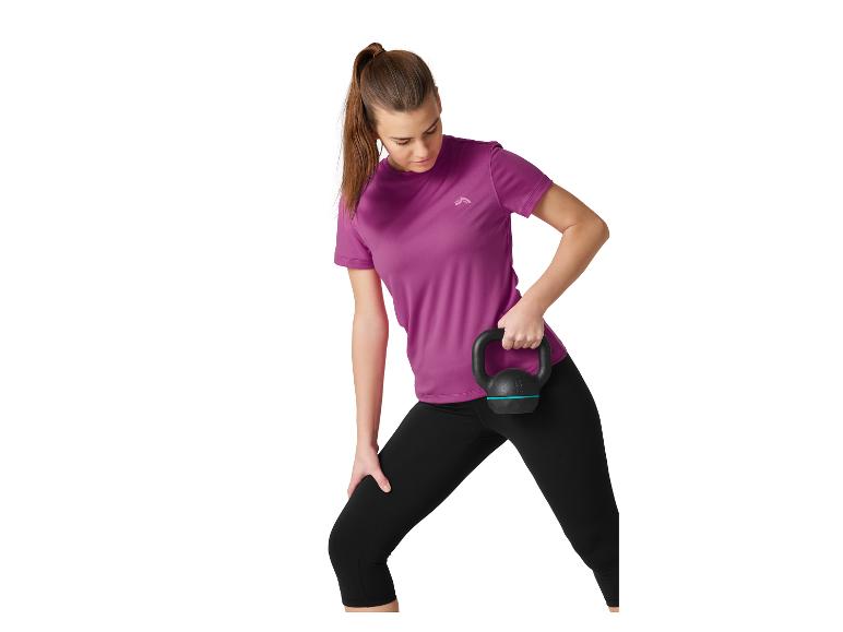 Vrouw in paarse en zwarte sportkleding, met een zwarte kettlebell.