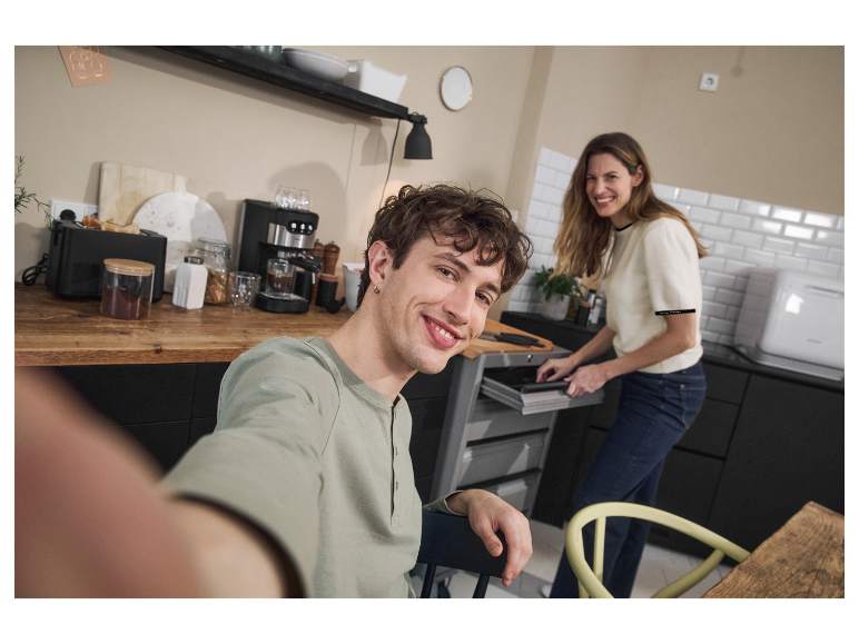 Een stel in een moderne keuken met ingebouwde apparaten.