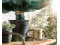 Potplant met beschermhoes en klos touw op een houten plank.