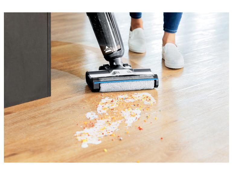 Bissell stofzuiger reinigt gemorste kleurrijke ontbijtgranen op een houten vloer.