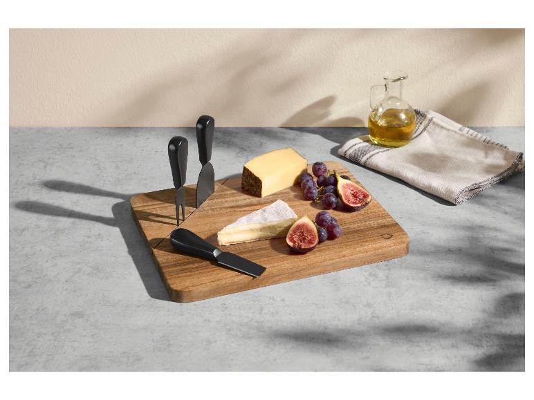 Kaasplank met messen, kazen, druiven en vijgen, met olijfolie en theedoek ernaast.